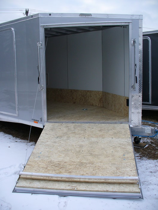 Enclosed trailer with V front ramp door